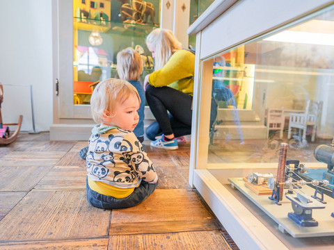 Eine Mutter mit zwei Kindern schaut sich die Ausstellung im Schloss Frohburg in der Leipzig Region an
