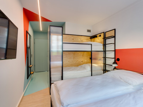 Ein 2+2 Zimmer im MEININGER Hotel Leipzig Hauptbahnhof mit Doppelbett und einem Hochbett 