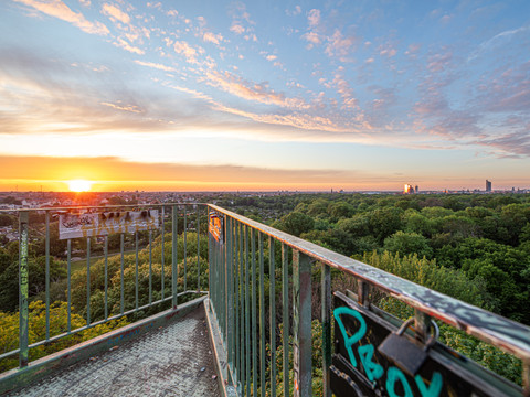 Blick vom Wackelturm im Rosental bei Sonnenaufgang auf die Leipziger City mit dem City-Hochhaus in der Ferne, Park, Aussichtspunkt, Grünes, Familie