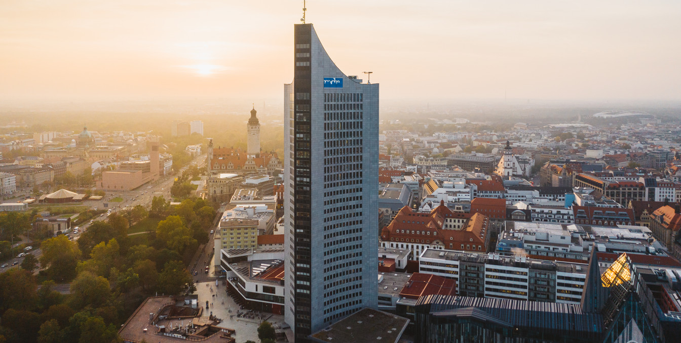 Blick auf die Skyline von Leipzig mit dem City-Hochhaus, der Moritzbastei, dem Neuen Rathaus und der Innenstadt während des Sonnenuntergangs, Sehenswürdigkeit, Architektur