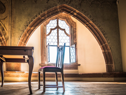 Tisch und Stuhl vor dem großen Fenster im Schloss Rochlitz