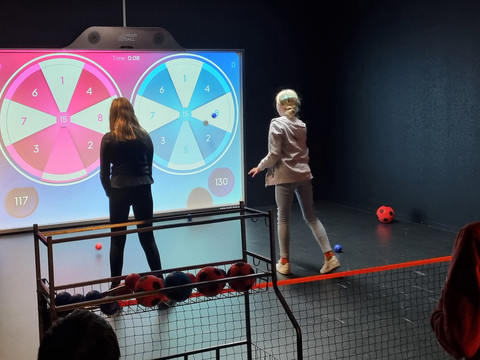 Zwei Kinder spielen Dart an der XXL Spielewand von Team-Duell Leipzig