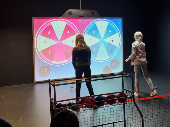 Zwei Kinder spielen Dart an der XXL Spielewand von Team-Duell Leipzig