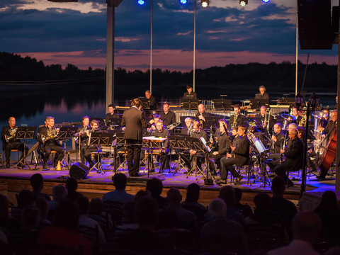 Konzert der Sächsischen Bläserphilharmonie am Biedermeierstrand am Abend mit See im Hintergrund