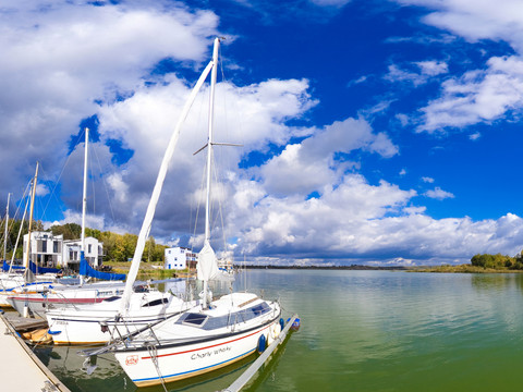 Boote liegen in der Lagune in Kahnsdorf an, Wasser, blauer Himmel, Wolken, Bäume, Häuser, Steg