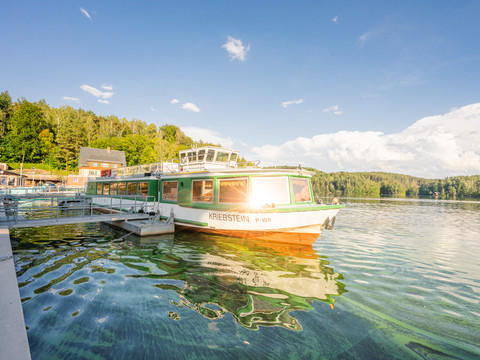 Boot mit dem Namen Kriebstein am Anleger am Stausee Zschopau, Bäume, blauer Himmel