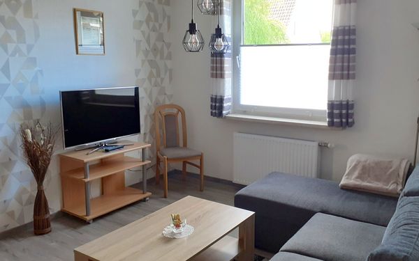 Wohnzimmer mit Zugang zum Wintergarten der Ferienwohnung Pülsch