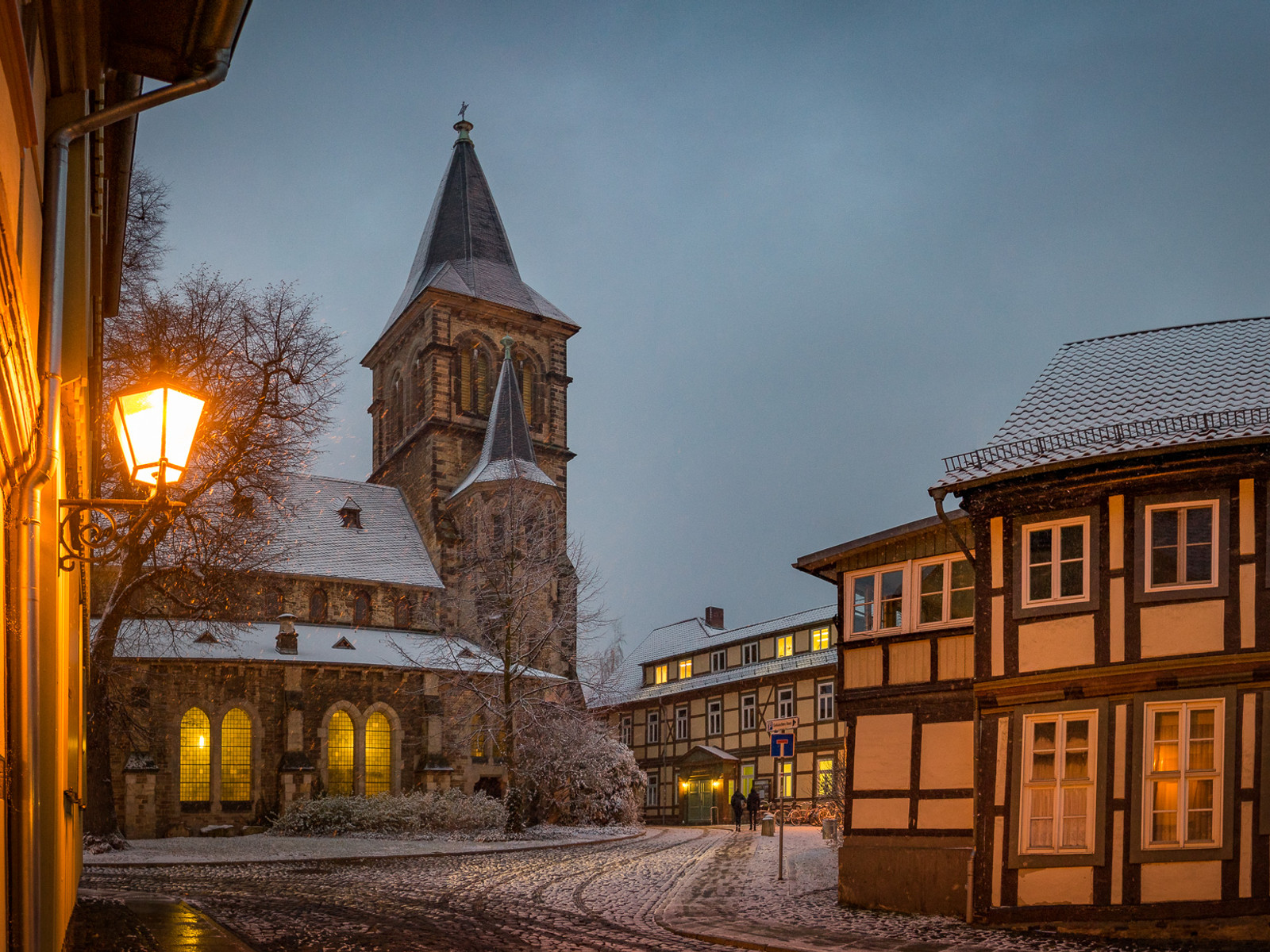 Verschneiter Winterabend an der St. Sylvestri Kirche in Wernigerode mit Laternenlicht.