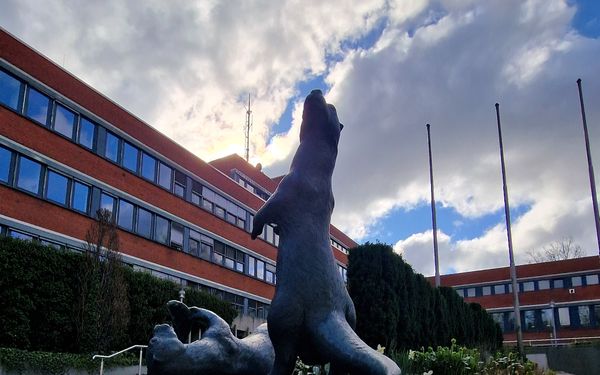 Otterskulptur unter'm Wolkenhimmel