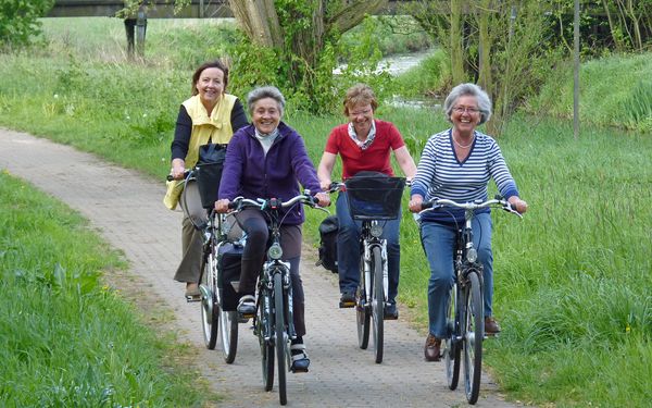 Vier Frauen auf einem gepflasterten Radweg