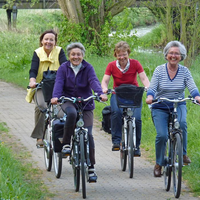 Vier Frauen auf einem gepflasterten Radweg