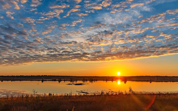Sonnenaufgang über den Wasserflächen des Tister Bauernmoores