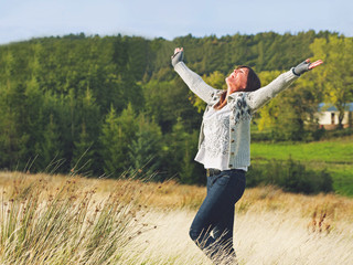 Young Woman Enjoying Freedom Outdoors in Autumn Landscape