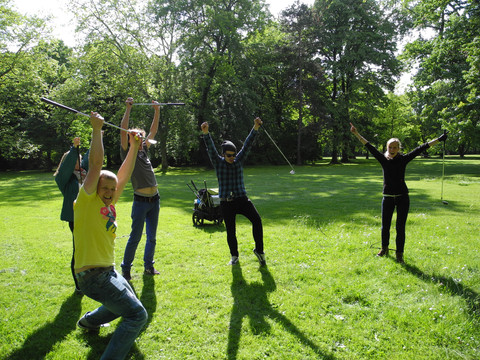 Eine Gruppe von fünf Menschen jubelt da sie beim Crossgolf des Freizeitanbieters betourt im Park gewonnen haben, Erlebnis