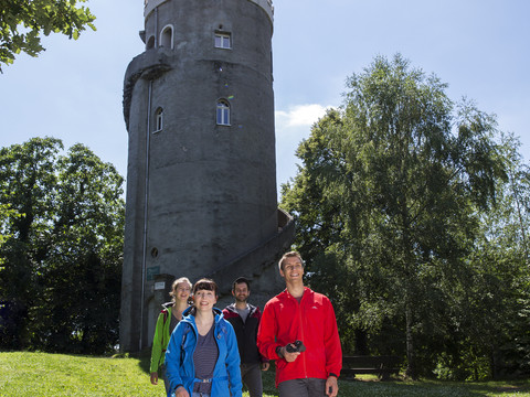 Eine Gruppe von Wanderern am Albertturm im Collm, einem Waldgebiet in Wermsdorf bei Sonnenschein und blauem Himmel, Wandern, Aktiv, Natur, Region