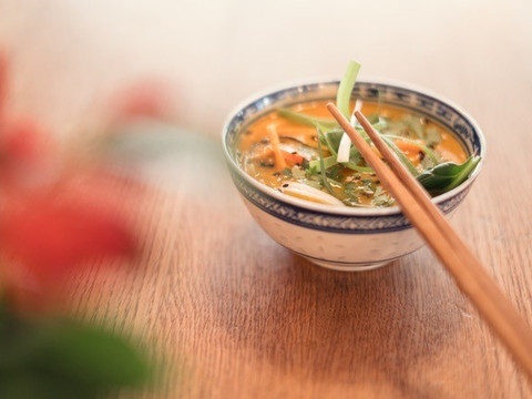 Eine Suppenschüssel steht mit Stäbchen auf einem Holztisch, Kulinarik, Freizeit, Essen