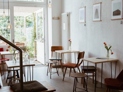 Zusehen ist der Blick in das leere Café: Es befinden sich einige Sitzgelegenheiten und Tische dort, Cafe, Gastronomie, Freizeit 