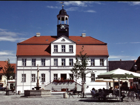 Frontaler Blick auf das Bad Dübener Rathaus mit rotem Ziegeldach und blauem Himmel, Sehenswürdigkeiten, Architektur, Geschichte