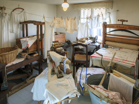 Blick in einen Raum voller Haushaltsgeräte inklusive einer Wäscherolle aus dem 19. Jahrhundert, Kultur, Geschichte, Freizeit