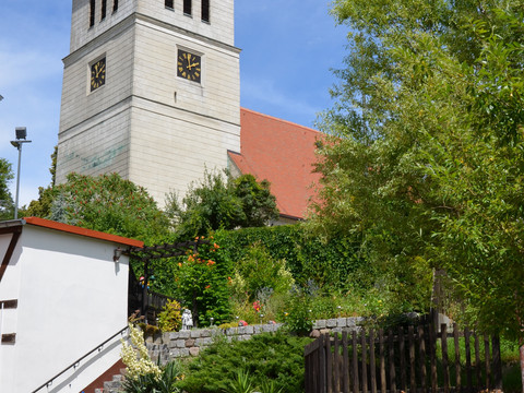 Blick auf das imposante Kirchgebäude mit Glockenturm in grüner Umgebung, Kirche, Kultur, Architektur