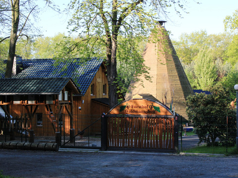 Eingangsbereich und Tor zum Forsthof im Wald, Hauptgebäude und Tippi-Zelt im Hintergrund, Familienausflug