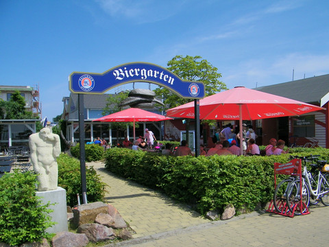 Biergarten mit Besuchern und roten Schirmen bei Sonnenschein am Cospudener See, Gastronomie, Biergarten, Freizeit