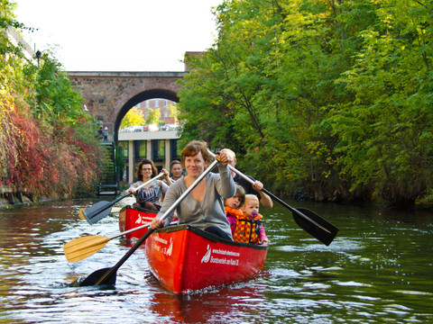 Eine Familie mit Kindern paddelt mit zwei Kanus über einen Kanal in Leipzig, Freizeit, Leipzig mit Kindern