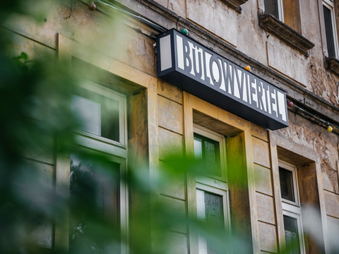 Blick auf eine abgewetzte Fassade im Bülowviertel, mit Leuchtbox-Schild mit eben dieser Beschriftung über einer der Türen , architektur, gründerzeit