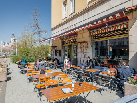Blick auf den Sonnigen Freisitz des Café Cantona mit Gartenmöbeln und Blick auf das Neue Rathaus, freisitz, freizeit, restaurant