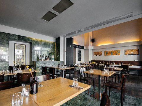 Blick in den Innenraum des Fela Restaurants, seine Tische und Dekorationen sowie die restliche moderne Inneneinrichtung