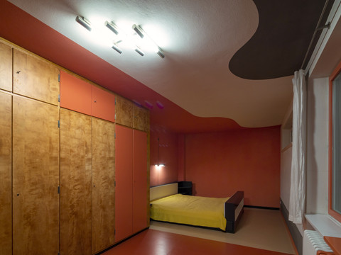 Im schlicht gehaltenem Schlafzimmer des Haus Rabe Zwenkau befindet sich eine große Schrankwand und ein Bett 