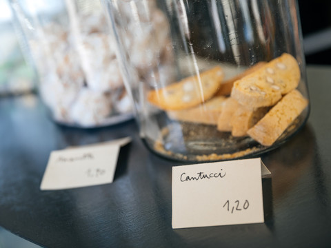 Fotografie der Süßwaren im INO Café, auf der Theke drapiert und mit Schriftschildchen versehen