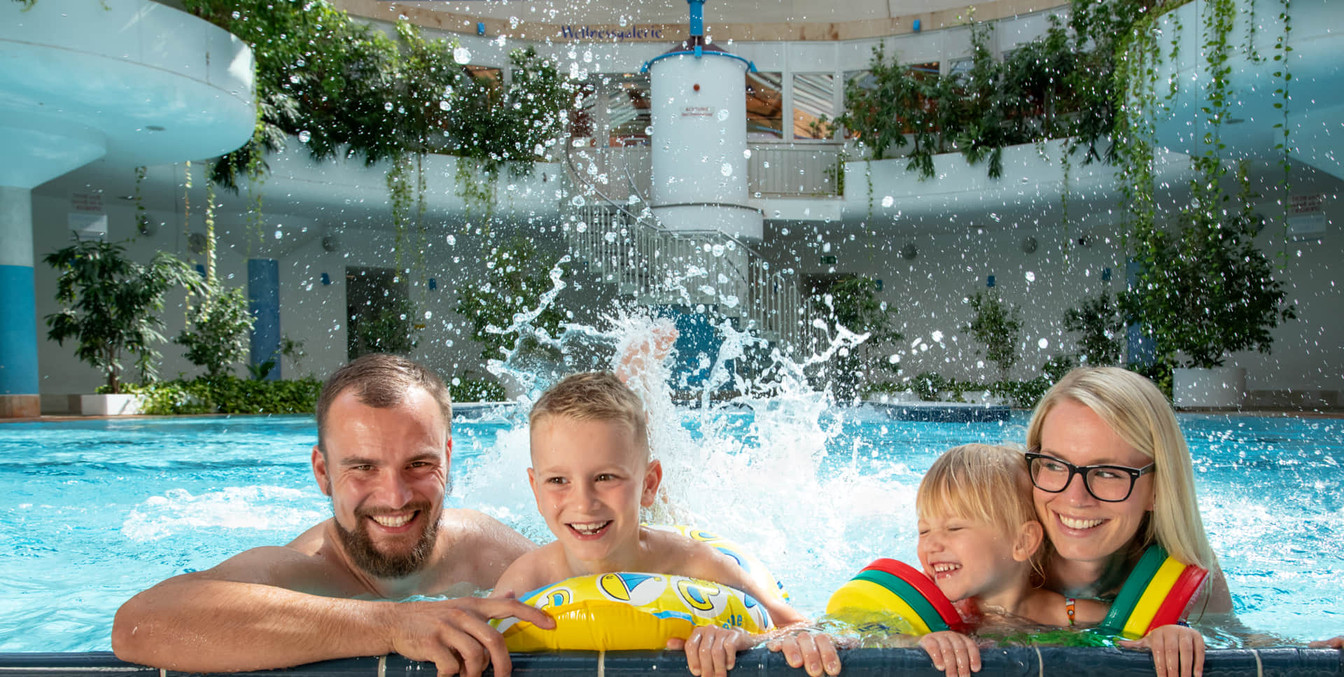 Eine Familie mit 2 Kindern plantscht am Beckenrand des RIFF's, Schwimmbad-Leipzig-mit-Kindern-Freizeit