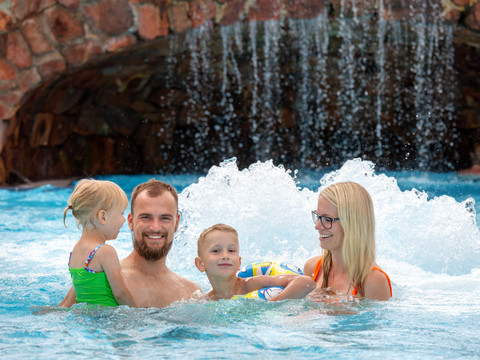 Eine glückliche Familie in einem sprudelnden Schwimmbecken des Freizeitbades Riff in Bad Lausick
