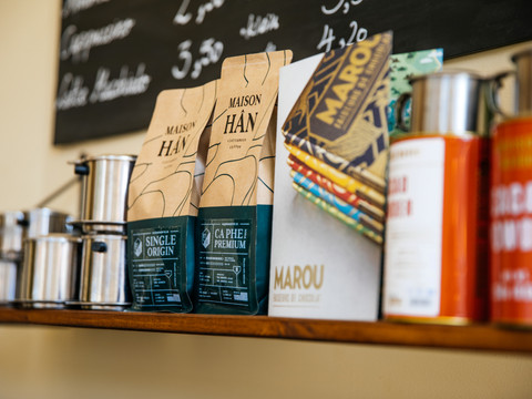 Detailaufnahme der ausgewählten Produkte im Regal des le caphe sowie die beschriftete Tafel im Hintergrund, cafe, gastronomie, kulinarik