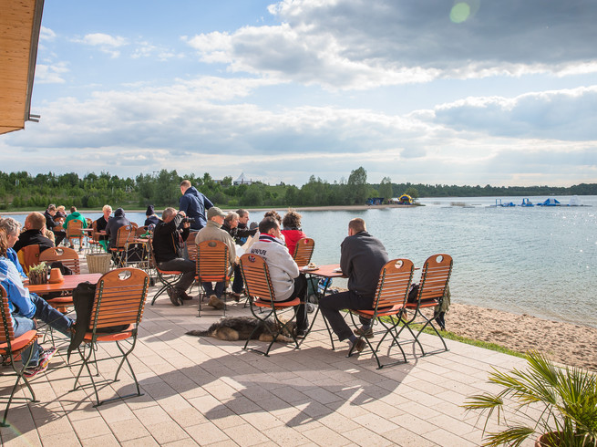 Auf der Terrasse des Restaurants Levante sitzen Gäste und genießen den einen weitläufigen Blick auf den Schladitzer See, Leipziger Neuseenland, gastronomie-restaurant