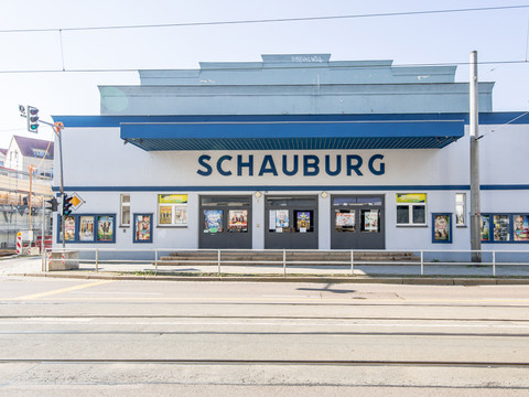 Blick auf das blau weiße Gebäude des Kinos Schauburg Leipzig an einem Sommertag.